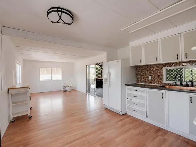 a kitchen with white cabinets and window