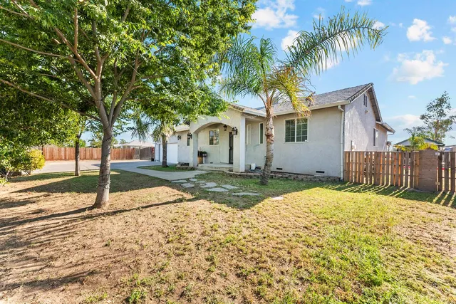 a bedroom with a bed a chandelier and a dresser