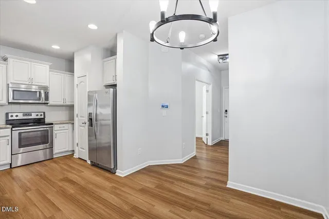 a kitchen with granite countertop a refrigerator and a stove top oven