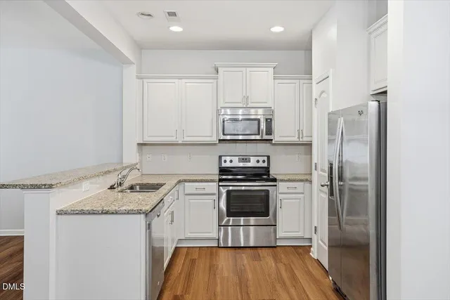 a kitchen with stainless steel appliances a refrigerator sink and microwave