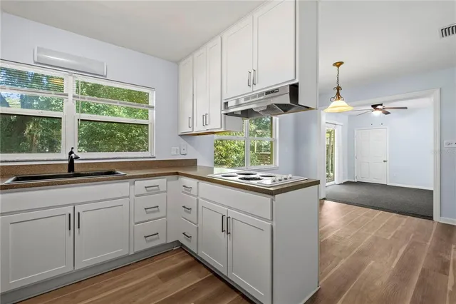 a kitchen with a stove a sink and a window