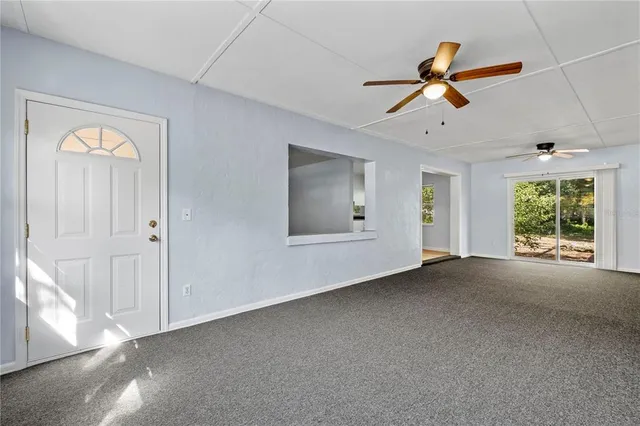 a view of a livingroom with a ceiling fan and windows