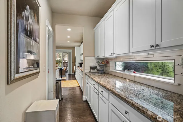 a kitchen with granite countertop a sink and stove top oven