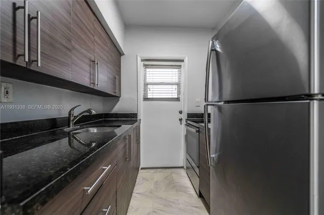 a kitchen with a refrigerator and a stove top oven