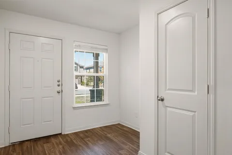 a view of an empty room with closet and a window