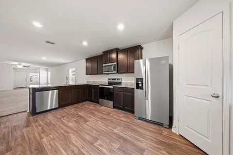 a large kitchen with a large window and stainless steel appliances