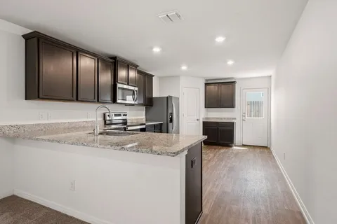 a kitchen with stainless steel appliances granite countertop a sink refrigerator and microwave