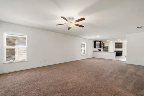 a view of a livingroom with a ceiling fan and window