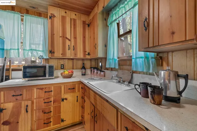 a kitchen with stainless steel appliances granite countertop a sink a stove and a wooden cabinets