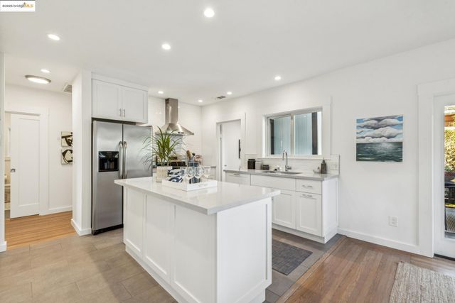 a kitchen with kitchen island white cabinets and refrigerator