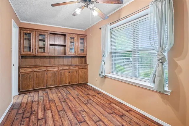 a room with wooden floor and windows