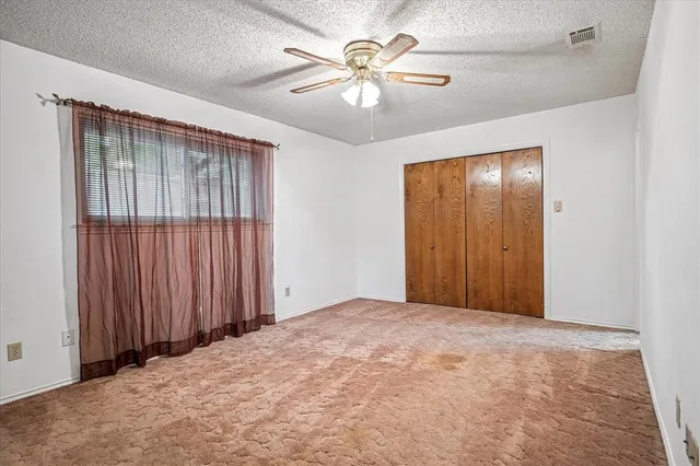 a view of an empty room with a ceiling fan