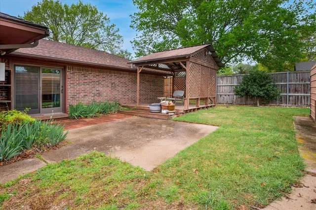 a view of a backyard with table and chairs under an umbrella