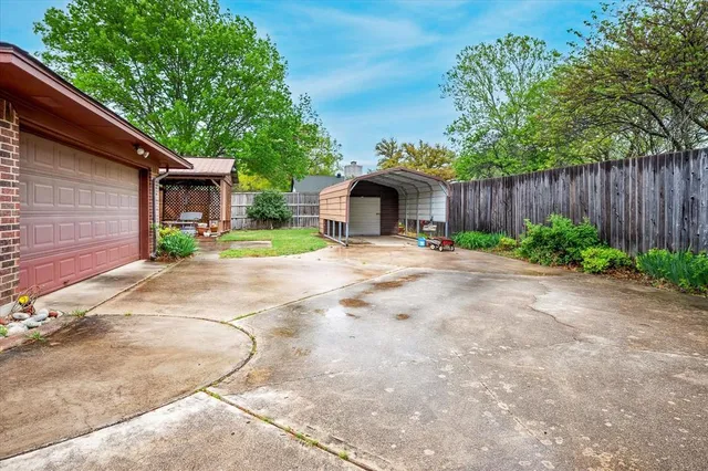 a view of backyard with table and chairs and potted plants