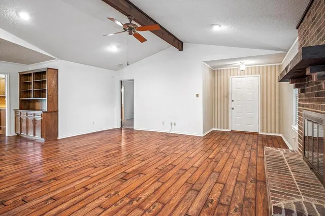 a view of empty room with wooden floor