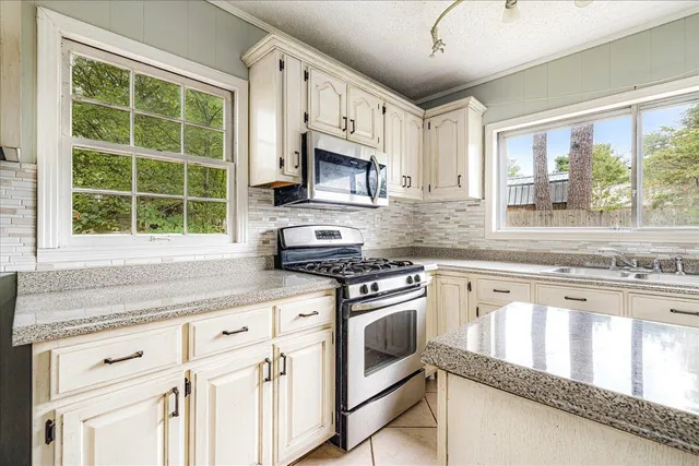 a kitchen with cabinets stainless steel appliances and a window