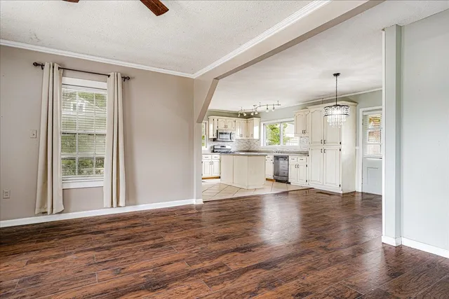 a view of a kitchen with wooden floor and a window