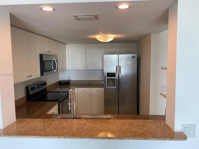 a kitchen with a refrigerator sink and stove