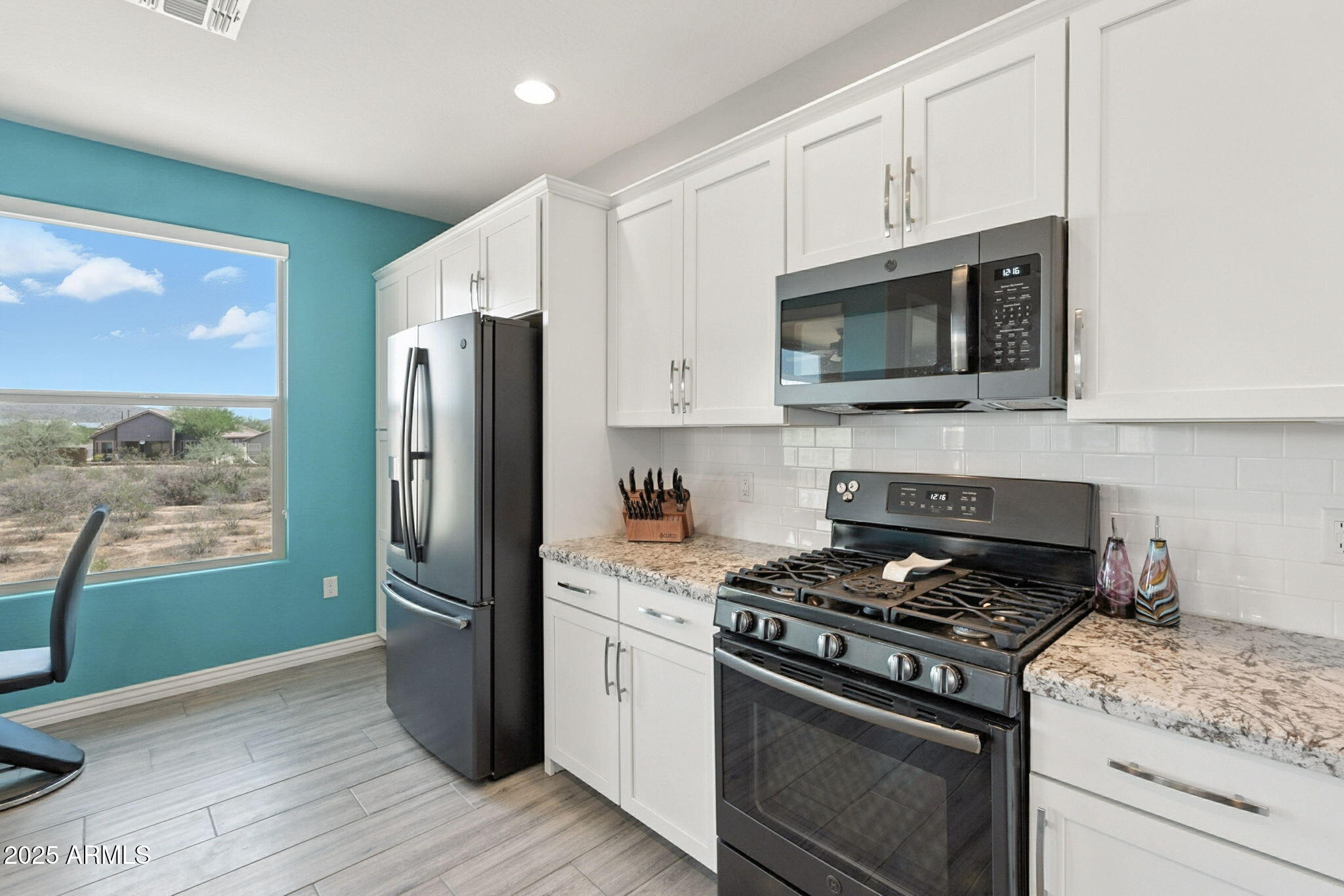 2425 West Bronco Butte Trail, Unit 2014 Phoenix, AZ 85085 - Photo 11 of 32 a kitchen with stainless steel appliances white cabinets a stove a refrigerator and a microwave
