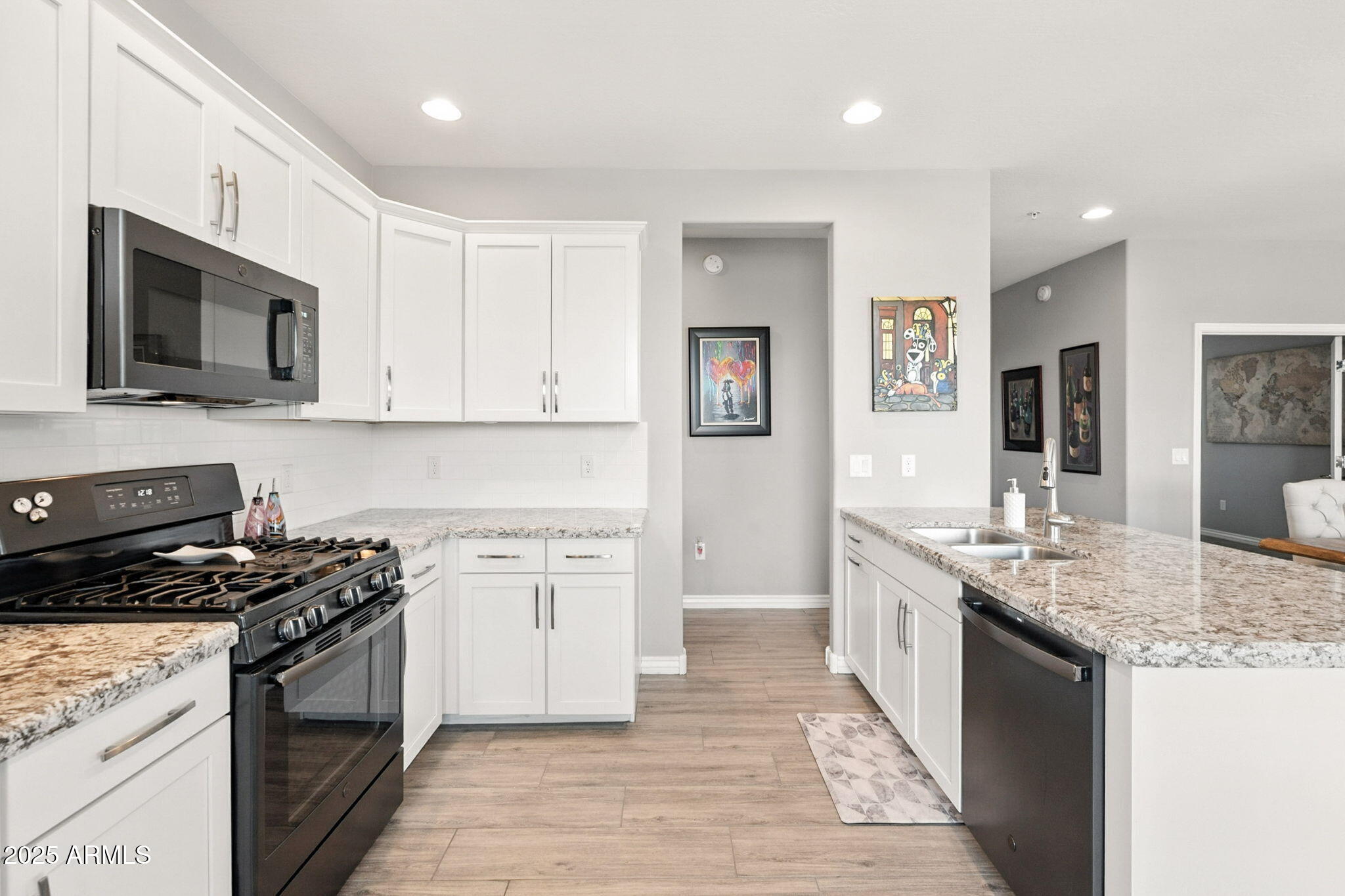2425 West Bronco Butte Trail, Unit 2014 Phoenix, AZ 85085 - Photo 15 of 32 a kitchen with stainless steel appliances granite countertop a stove top oven a sink dishwasher and a microwave oven with white cabinets