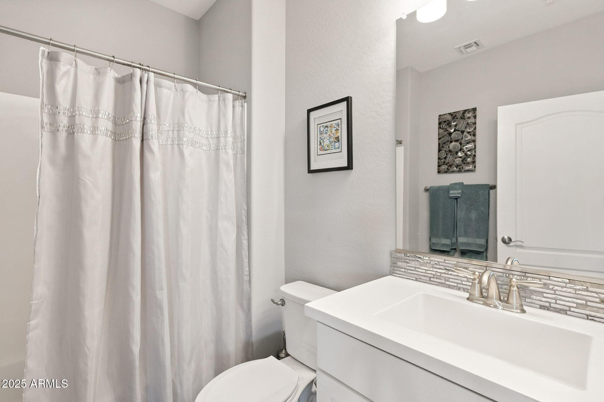 2425 West Bronco Butte Trail, Unit 2014 Phoenix, AZ 85085 - Photo 21 of 32 a bathroom with a sink a toilet and shower curtain