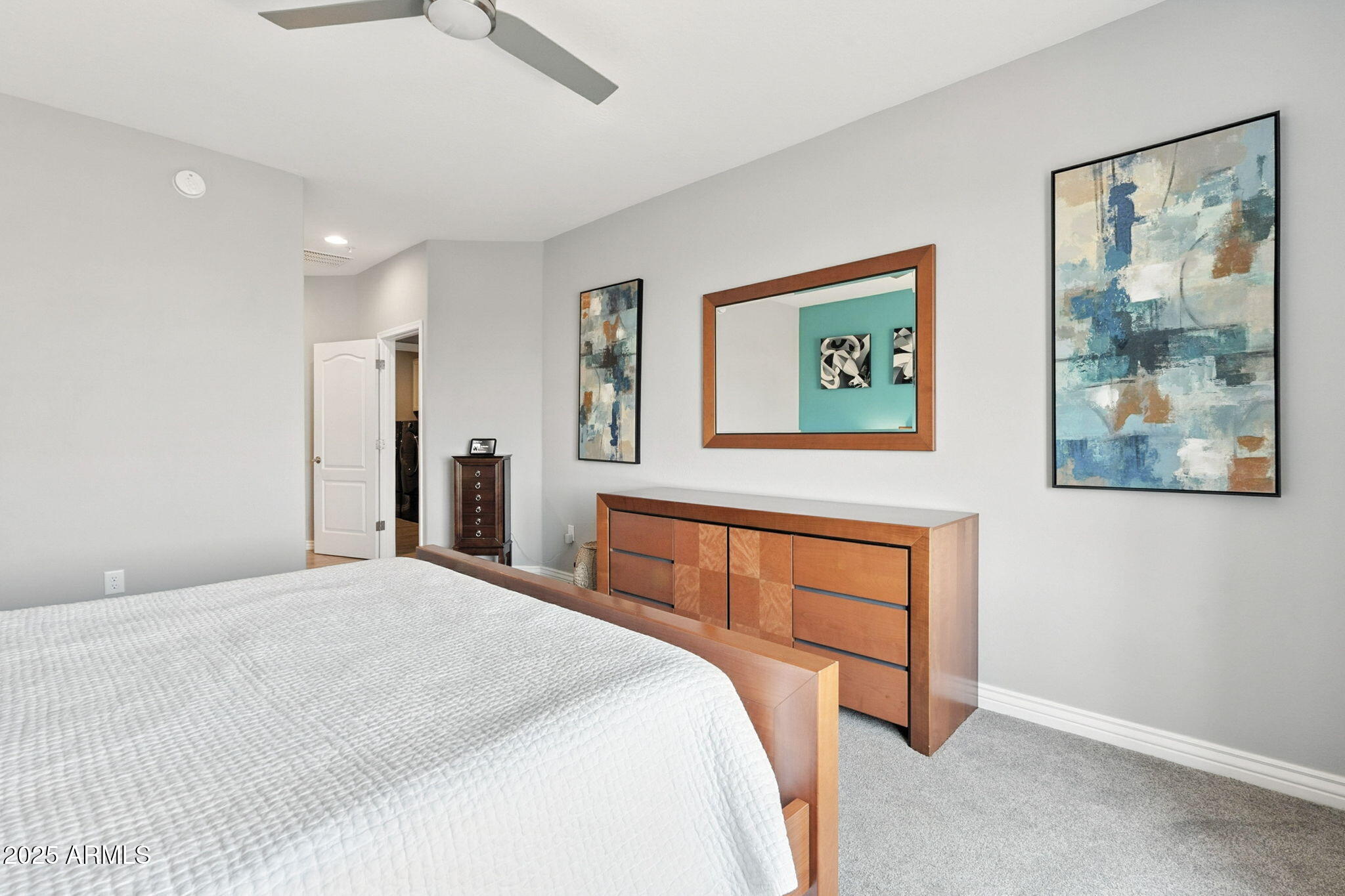 2425 West Bronco Butte Trail, Unit 2014 Phoenix, AZ 85085 - Photo 27 of 32 a bedroom with a large bed and a chandelier