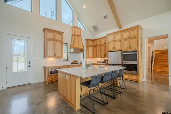 a kitchen with stainless steel appliances granite countertop a kitchen island hardwood floor sink stove dining table and chairs