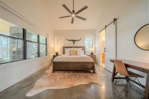 a bedroom with a bed a table and flat screen tv