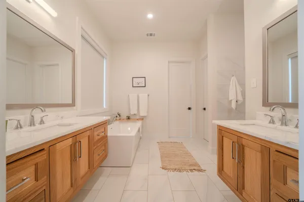 a bathroom with a tub sink and mirror
