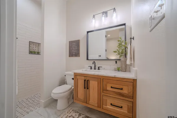 a bathroom with a toilet a sink and mirror