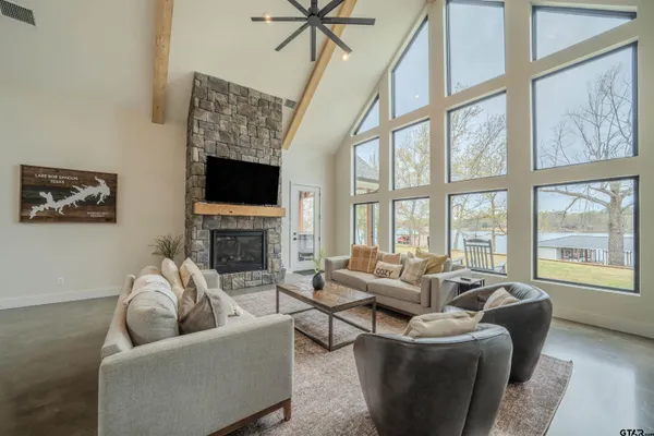 a living room with furniture a fireplace and a floor to ceiling window