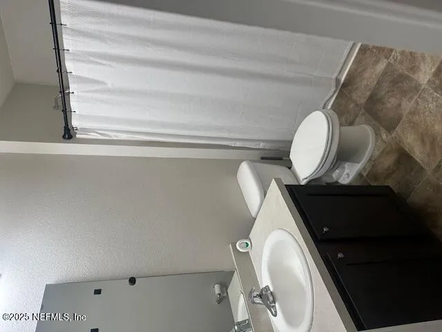 a bathroom with a toilet and a mirror