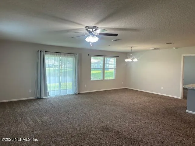 an empty room with windows and ceiling fan