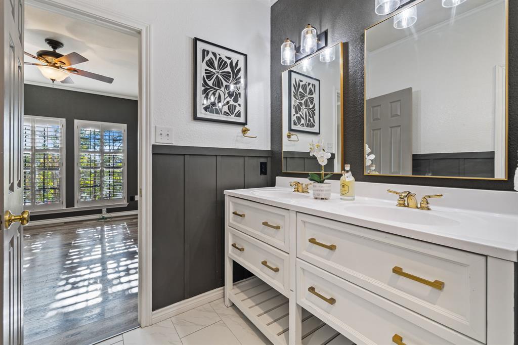 4134 Crossing Lane Dallas, TX 75220 - Photo 29 of 39 Bathroom featuring light marble finish floors, double vanity, crown molding, ceiling fan, and a wainscoted wall