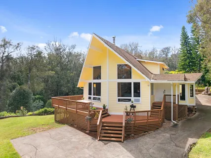 a view of a house with backyard and sitting area