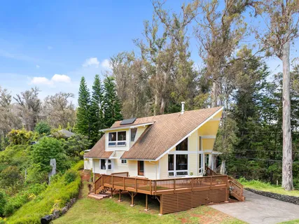 a aerial view of a house with swimming pool next to a yard