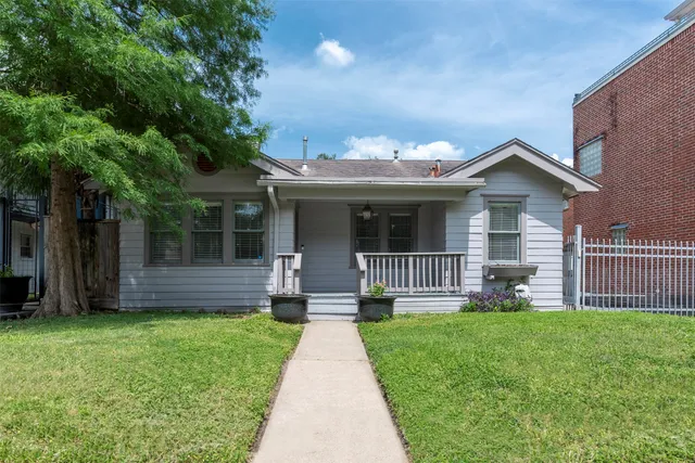 a front view of a house with a garden and yard