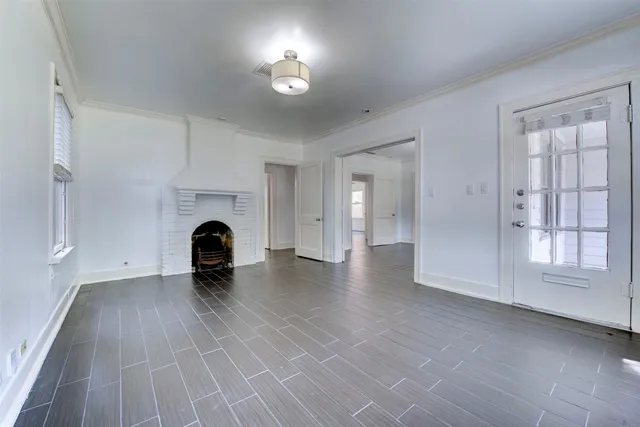 a view of empty room with fireplace and wooden floor