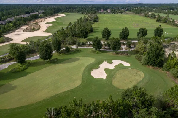 an aerial view of lake residential house with outdoor space and trees all around
