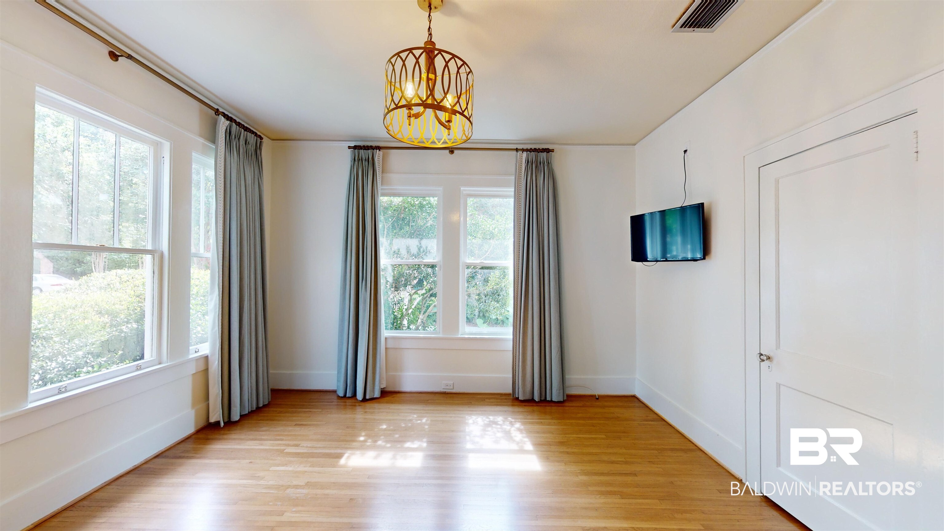 4307 Stein Street Mobile, AL 36608 - Photo 14 of 28 Spare room featuring a chandelier, a healthy amount of sunlight, and light wood-type flooring