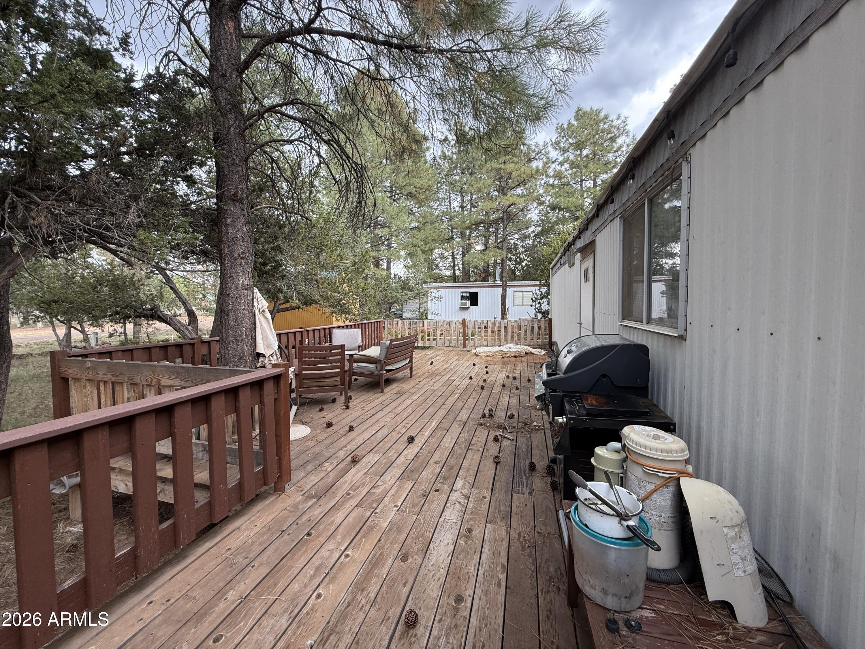 2953 Wildcat Trail Overgaard, AZ 85933 - Photo 7 of 22 a balcony with wooden floor and outdoor seating
