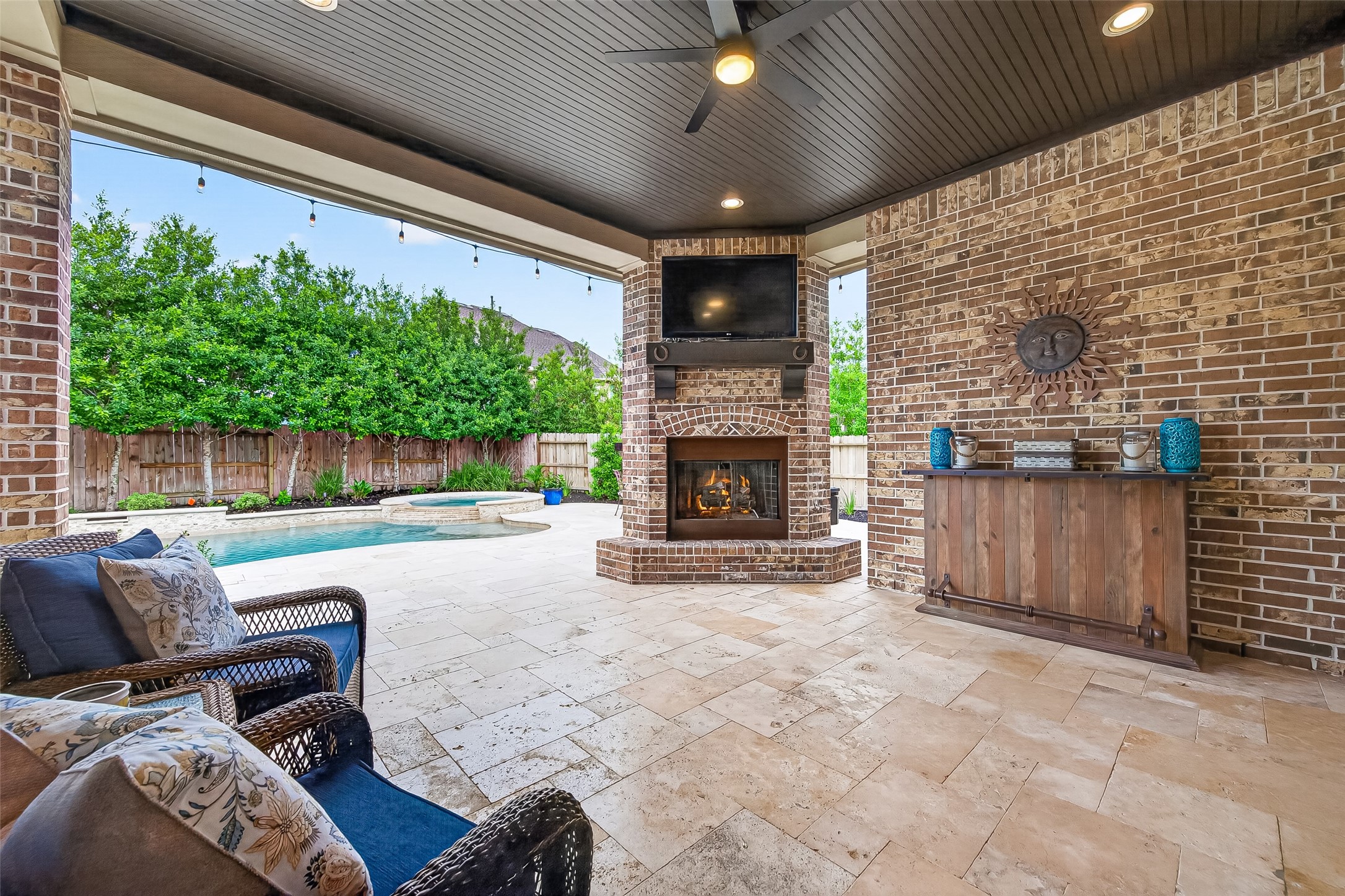 2803 Mayfield Ridge Lane Katy, TX 77494 - Photo 33 of 40 Extended covered patio with gas log fireplace, tongue and groove ceiling and travertine decking