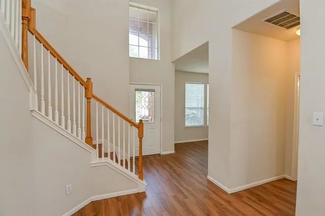 a view of a hallway with wooden floor and staircase