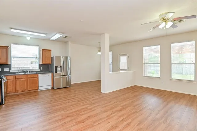 a view of kitchen with refrigerator stove and wooden floor