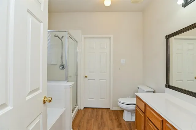 a bathroom with a granite countertop toilet a sink and a mirror