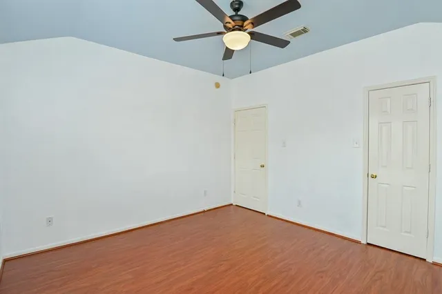 an empty room with a window and a fan