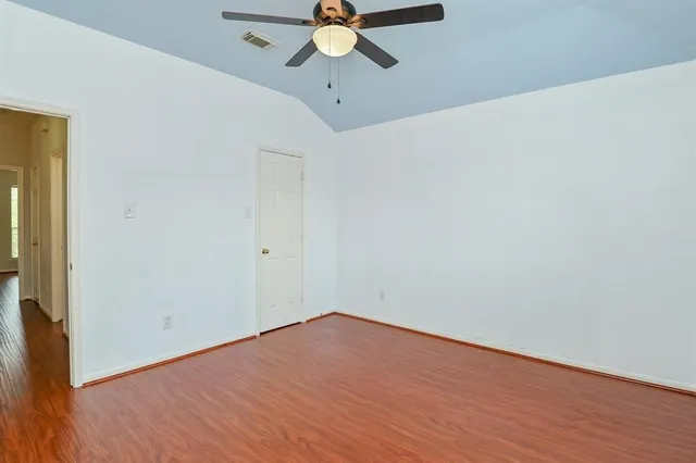 a view of a room with wooden floor and a ceiling fan