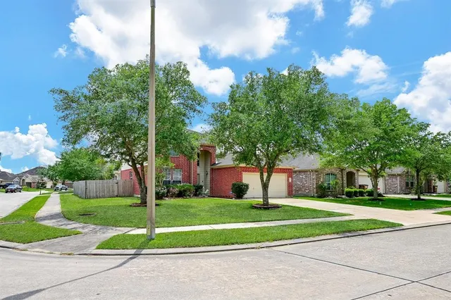 a view of a house with a big yard and large trees