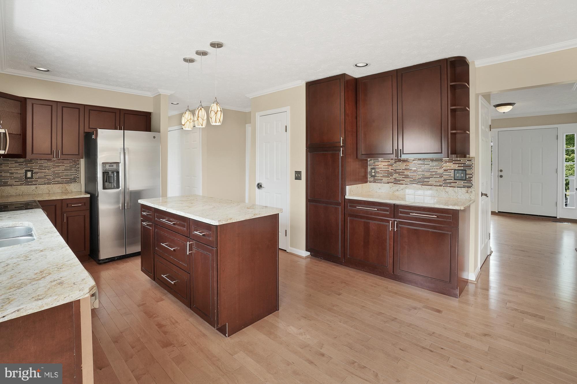 17205 Spates Hill Road Poolesville, MD 20837 - Photo 19 of 59 a kitchen with stainless steel appliances kitchen island granite countertop wooden cabinets and a counter top space