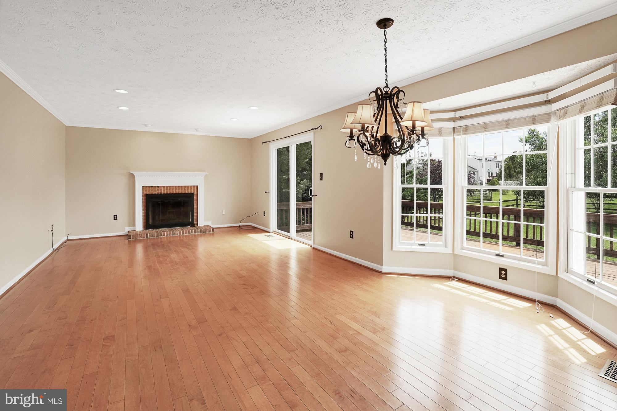 17205 Spates Hill Road Poolesville, MD 20837 - Photo 23 of 59 a view of empty room with wooden floor and fireplace